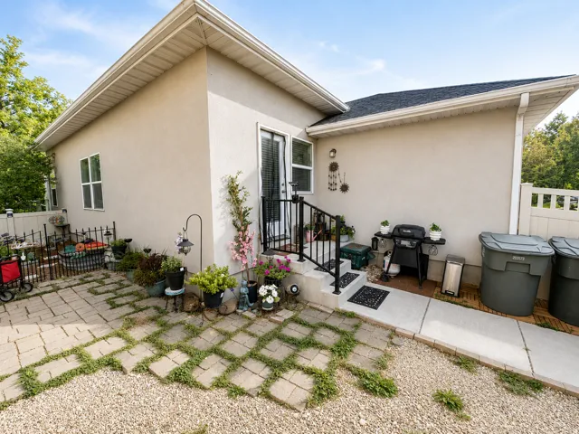 Stucco exterior with a black shingle roof and white gutters