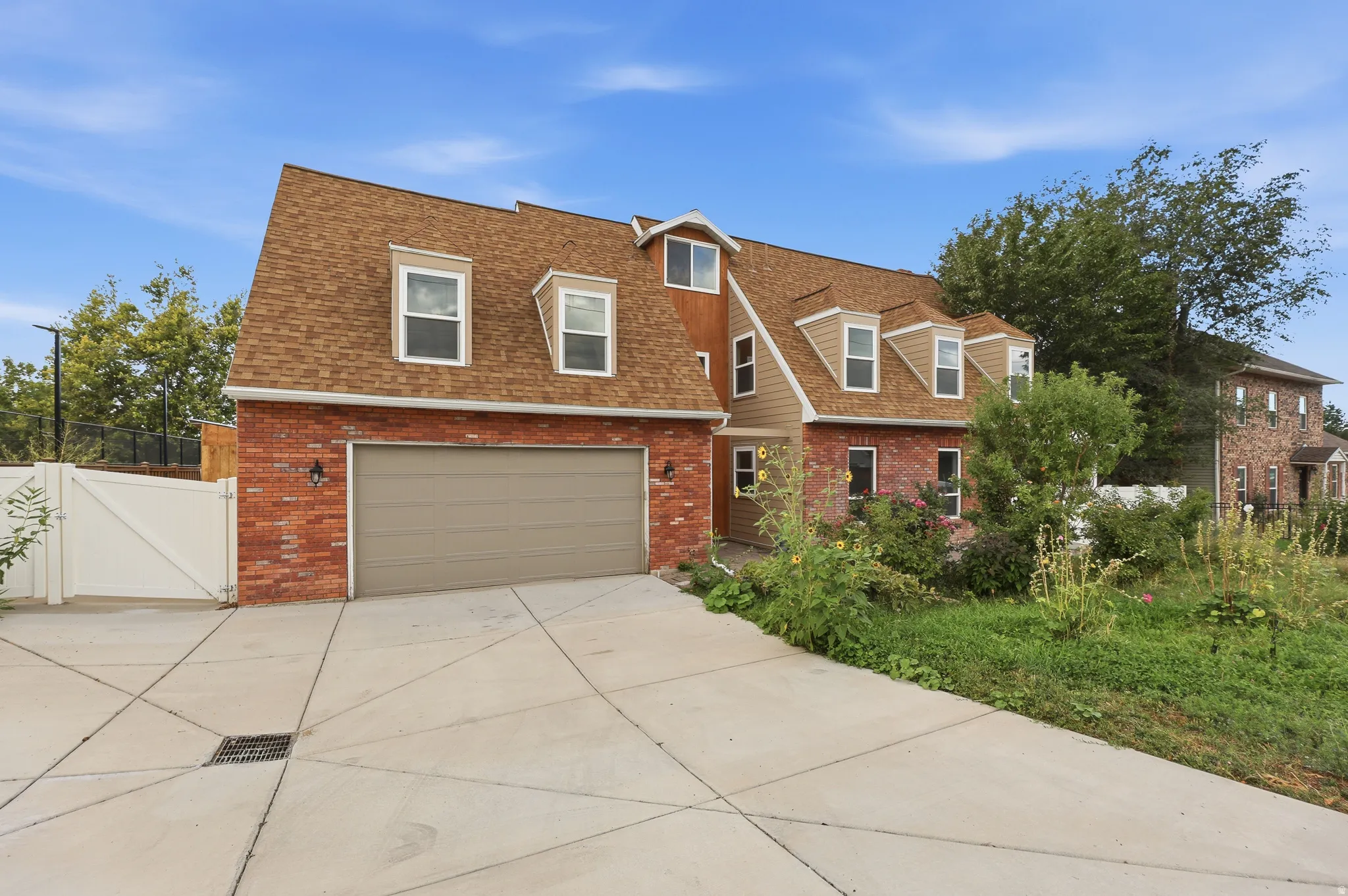 Brick and siding exterior with a gambrel roof and multiple dormer windows