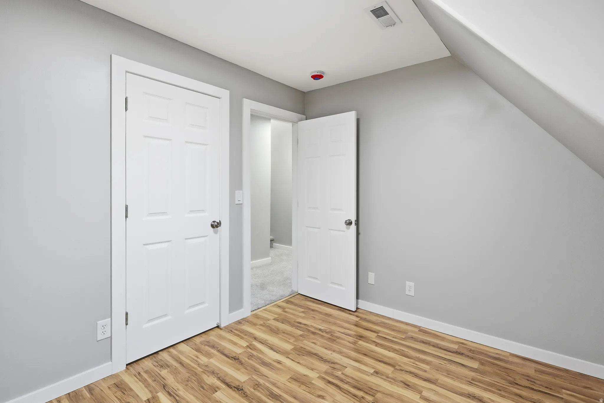 Wood-finish flooring, light gray wall paint, and white trim throughout