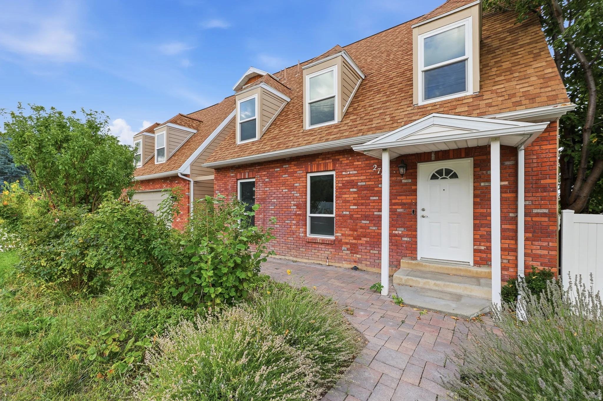 Red brick exterior with a prominent gabled roof featuring dormer windows