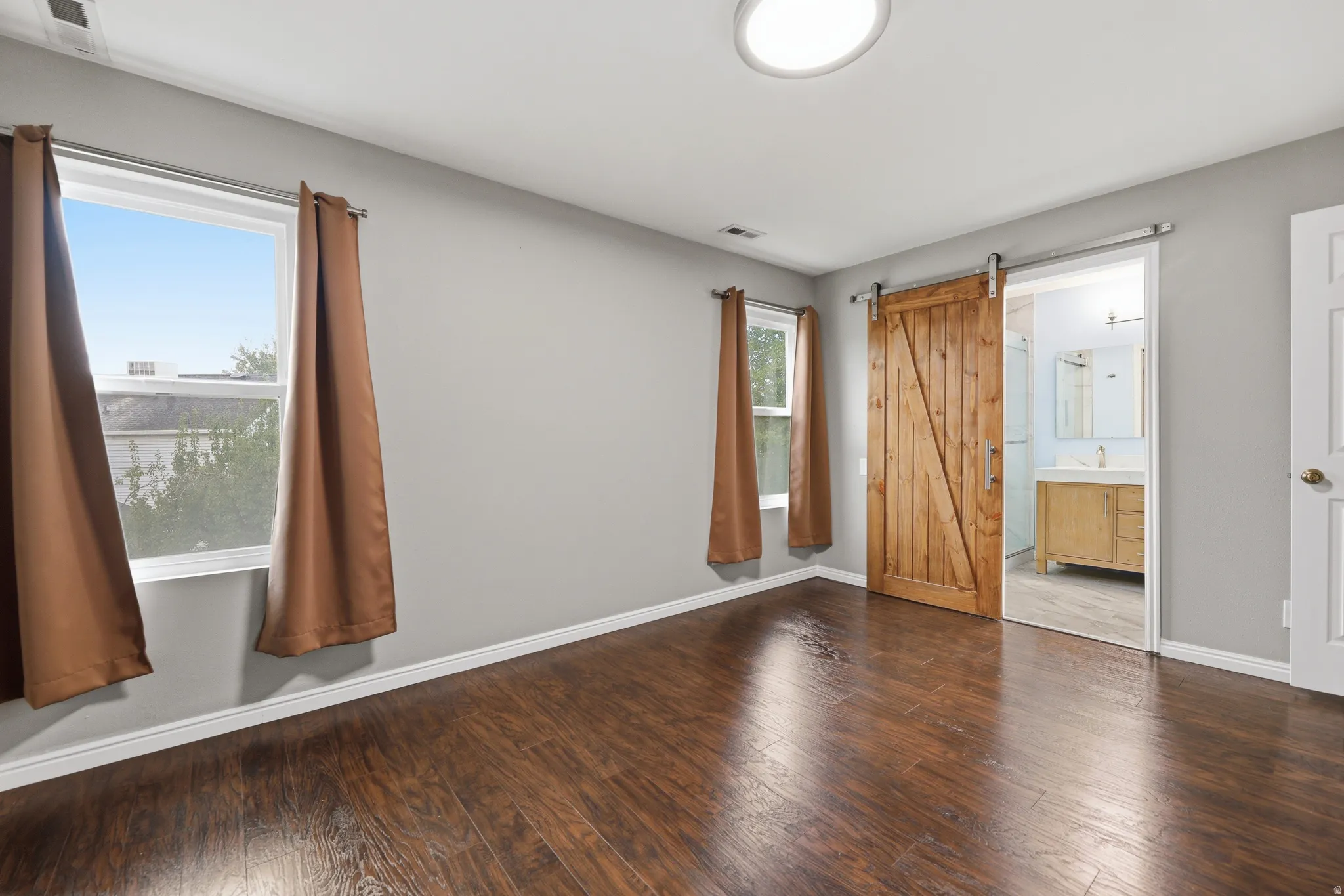 Wood-finish flooring, light gray walls, and a recessed ceiling light