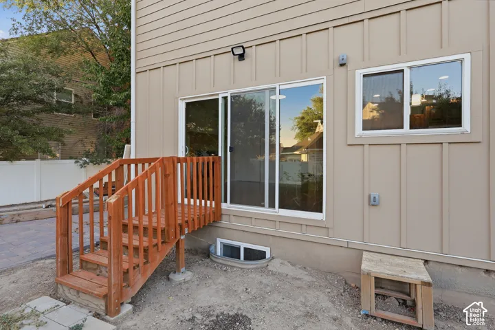 Sliding glass door access to exterior, wood deck and stairs, durable siding, and an egress window well