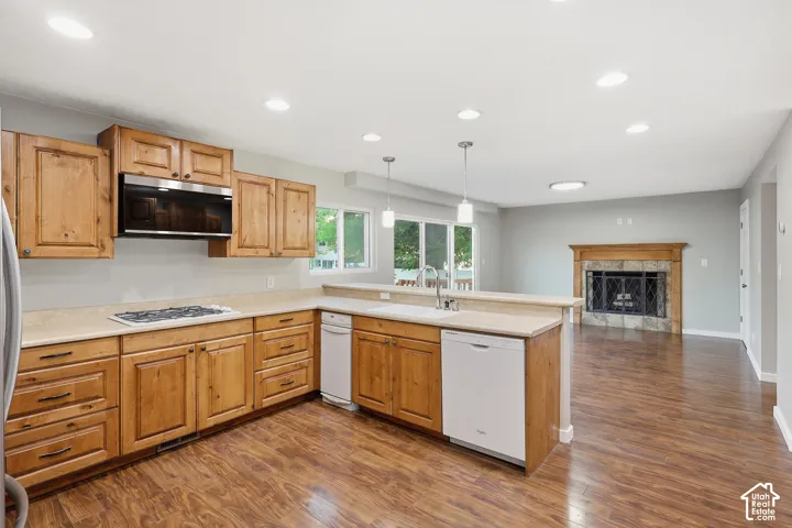 Kitchen featuring wood cabinetry, stone-finish countertops, and wood-finish flooring