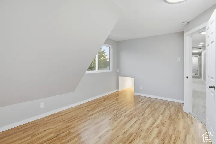 Wood-finish flooring, white trim, recessed lighting, white interior door, and a window for natural light