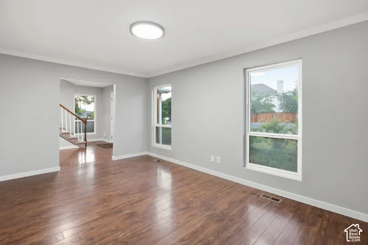 Wood-finish flooring, white trim, recessed lighting, and multiple windows with white frames