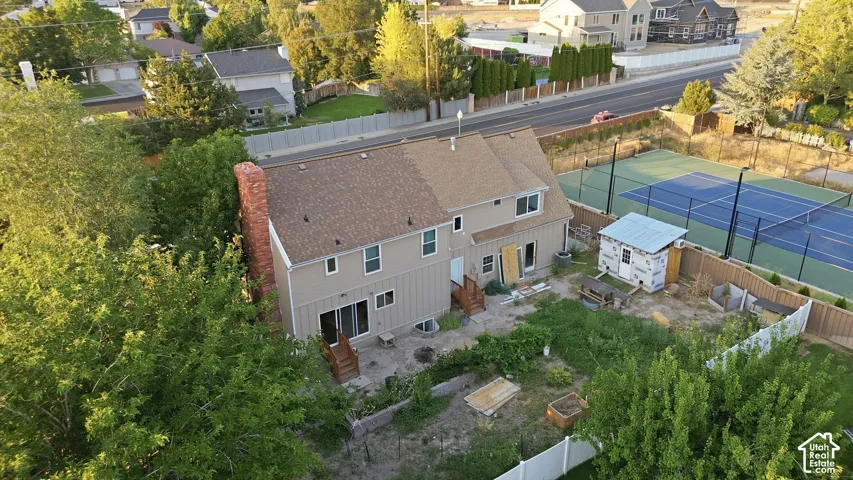 Two-story residence featuring a shingled roof, brick chimney, and rear patio doors
