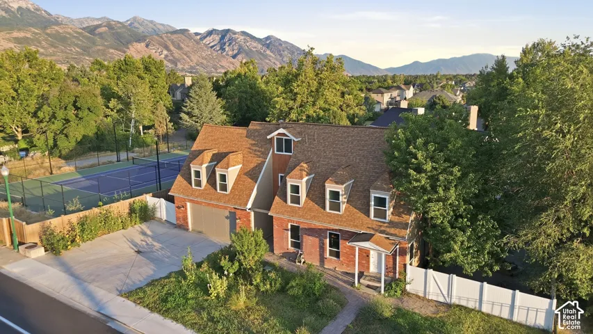 Brick exterior residence with a brown shingle roof and dormer windows