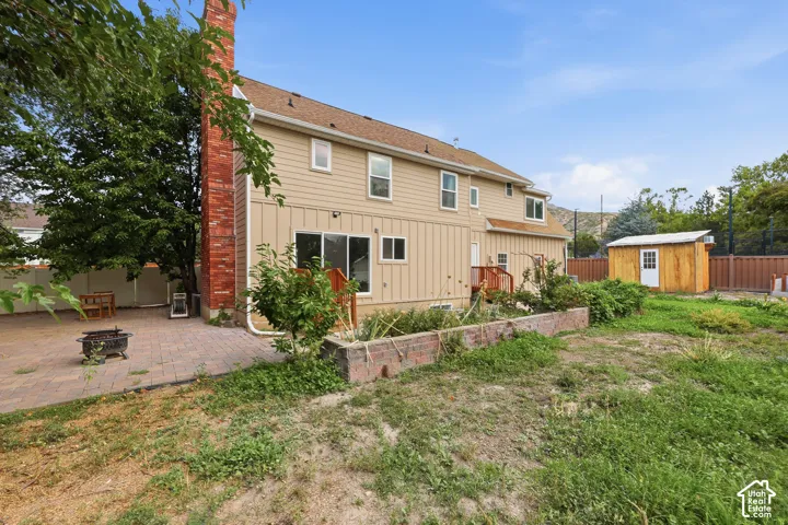 Two-story exterior with siding, a brick chimney, and a ground-level patio