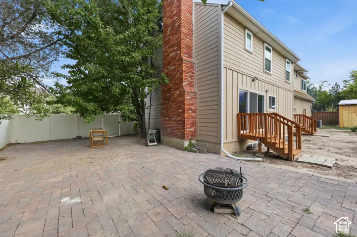 Expansive paver patio with a white privacy fence