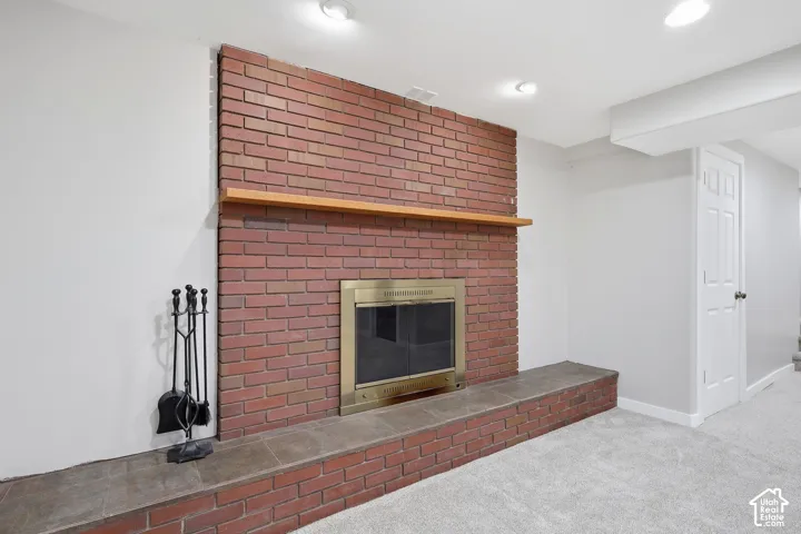 Brick fireplace with a brass firebox, stone hearth, and wood mantel