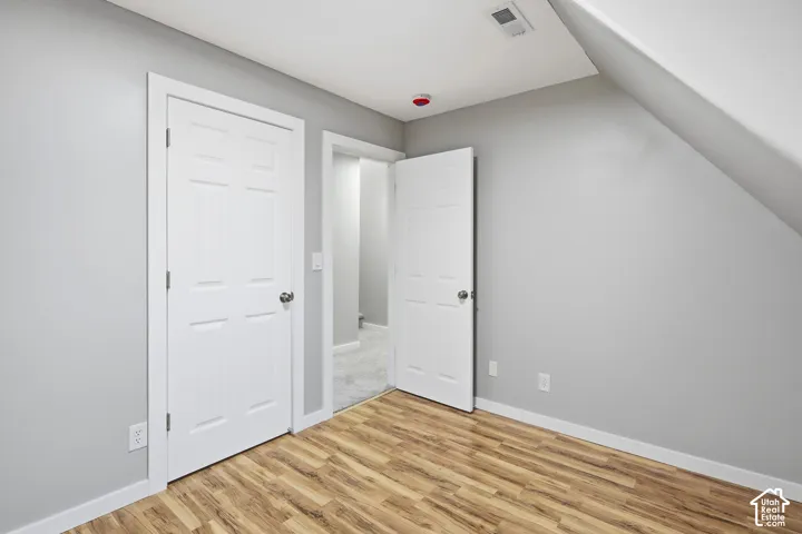 Wood-finish flooring, light gray wall paint, and white trim throughout