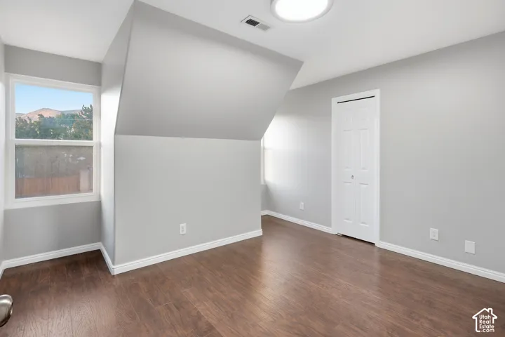 Hardwood-finish flooring, white baseboards, and a neutral wall color complement the room
