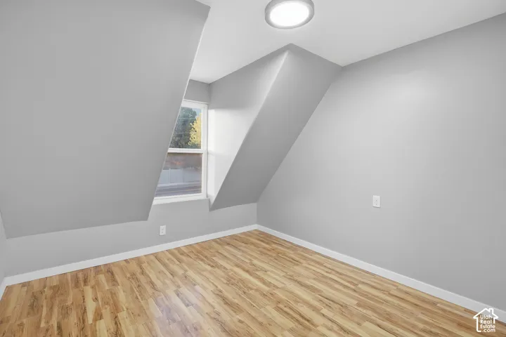 Sloped ceilings, wood-finish flooring, and a flush mount lighting fixture
