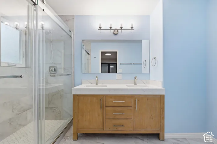 Dual vanity with light wood-finish cabinetry, white countertop, and brushed nickel fixtures