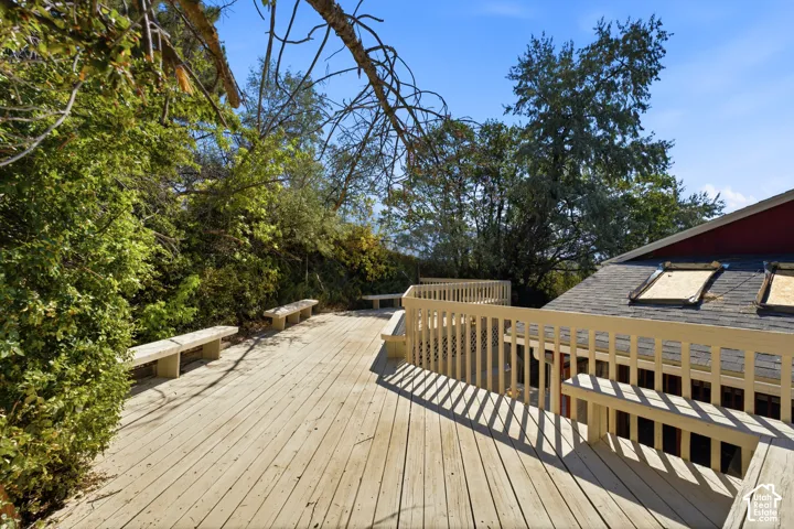 Expansive outdoor deck with integrated seating, surrounded by mature trees