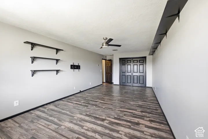 Wood-finish flooring with light gray walls, dark trim, and ceiling fan