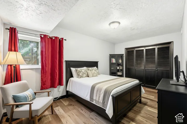 Wood-finish flooring, white walls, and a window with a white frame