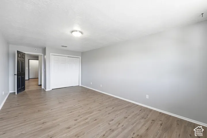 Wood-finish flooring, light gray wall tones, white bi-fold closet doors, and recessed lighting