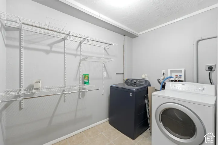 Laundry area featuring tile flooring, white wire shelving, and overhead lighting