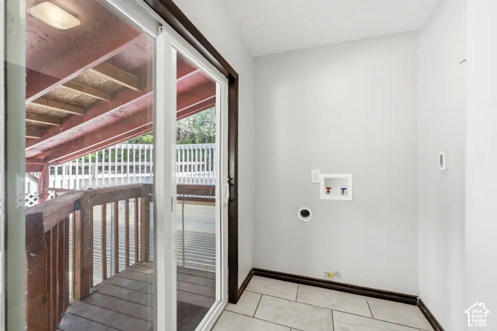 Interior room with light gray walls, tile flooring, and a dark baseboard trim