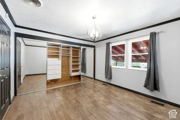 Wood-finish flooring with a custom built-in closet system featuring drawers and shelving