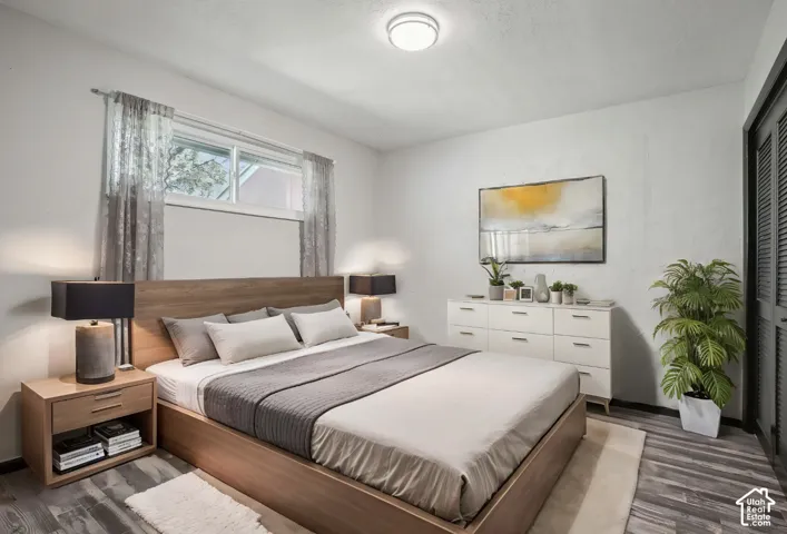 Natural light from a double-paned window, wood-finish flooring, and a flush-mount ceiling light