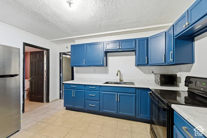 Kitchen featuring blue cabinetry, light countertops, and tile flooring