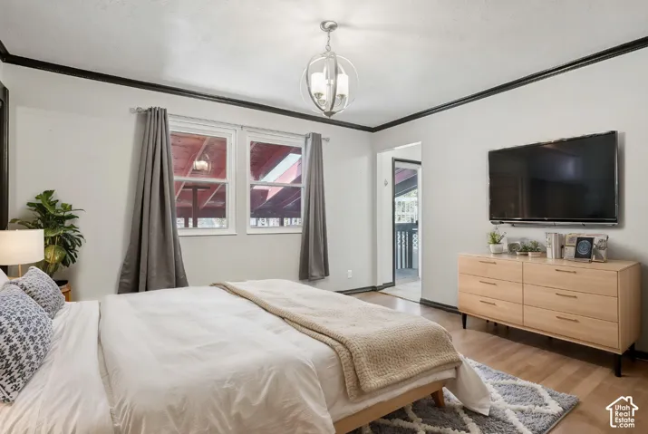 Hardwood-style flooring, white walls with dark trim, and a contemporary spherical chandelier