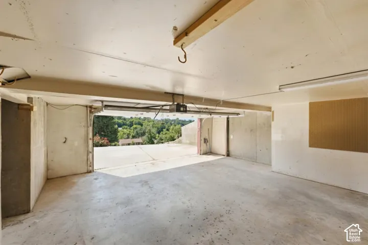 Concrete flooring in a spacious garage with a partial overhead door