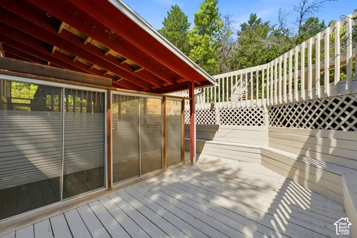 Wood-finish deck with built-in seating, lattice railing, and a covered patio area