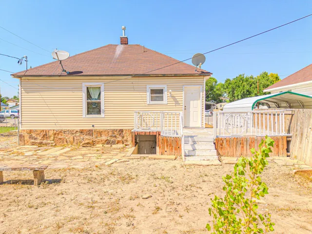 Rear exterior featuring light-colored siding and a stone foundation