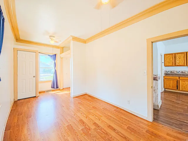 Wood-finish flooring throughout, crown molding, and a built-in ceiling fan