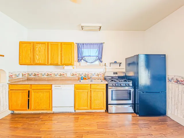 Wood-finish flooring, wood cabinetry, stainless steel range, and dishwasher