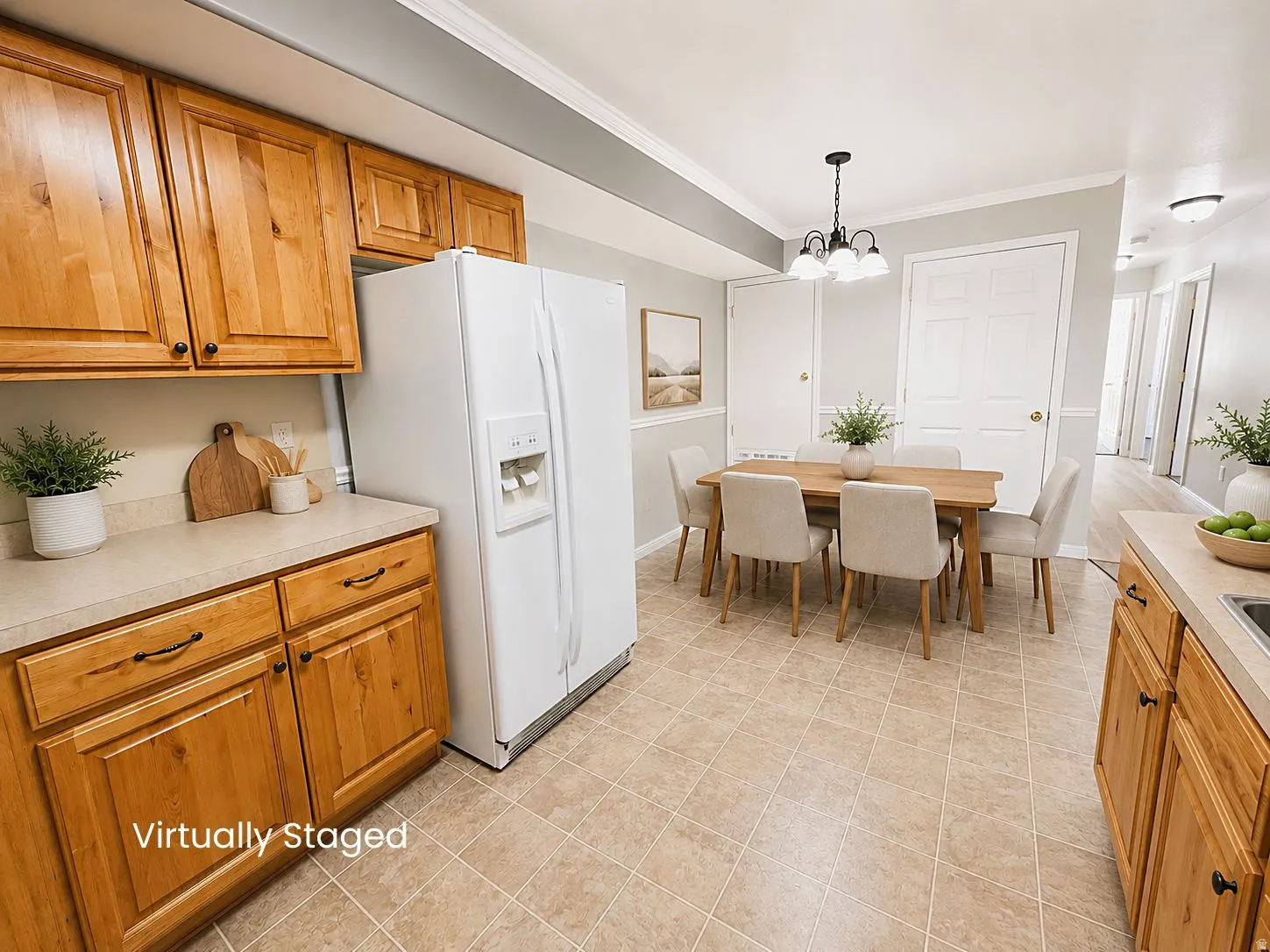 Kitchen with light wood cabinetry, white appliances, and a dining area featuring a chandelier