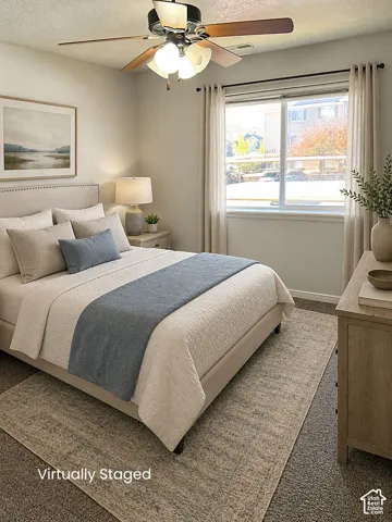 Spacious room with a ceiling fan, neutral wall paint, and a large window