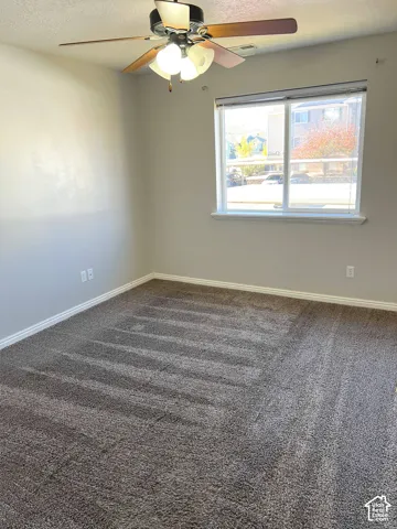 Neutral wall paint, ceiling fan with light fixture, white trim, and carpeted flooring
