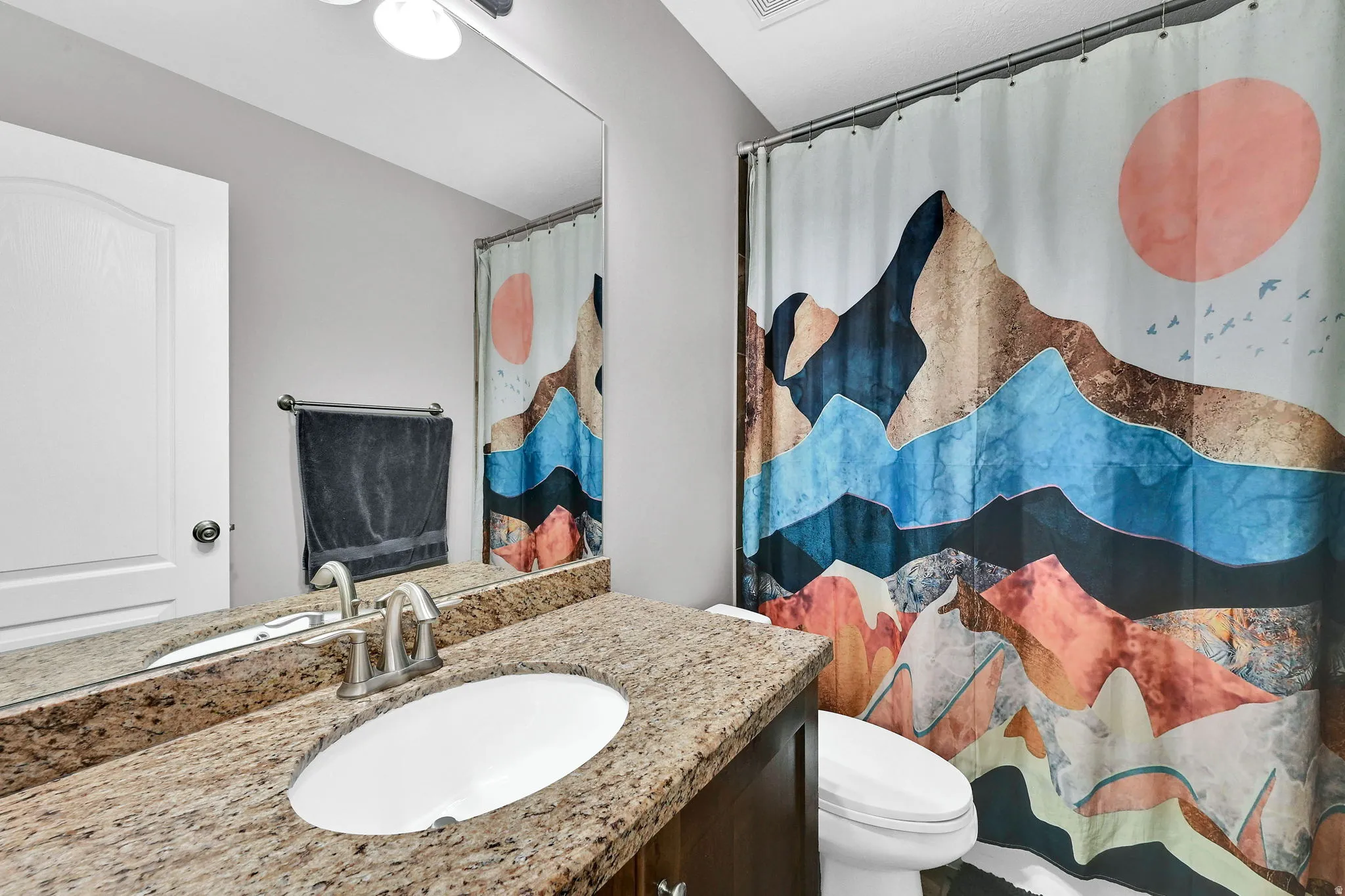 Vanity with integrated sink, stone-finish countertop, and brushed nickel faucet