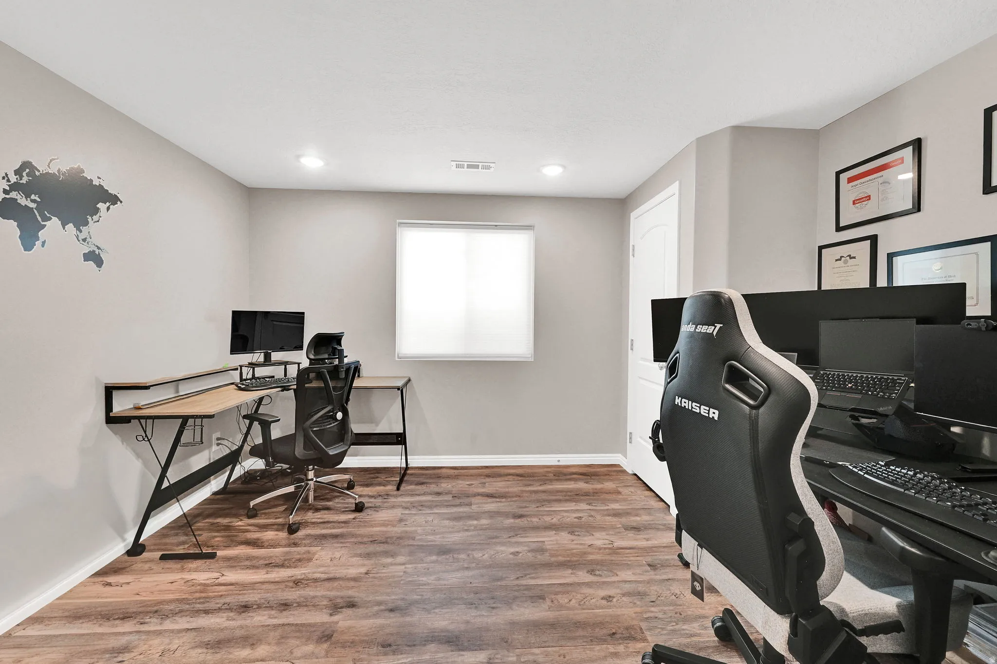 Recessed lighting, wood-finish flooring, and a window with a roller shade