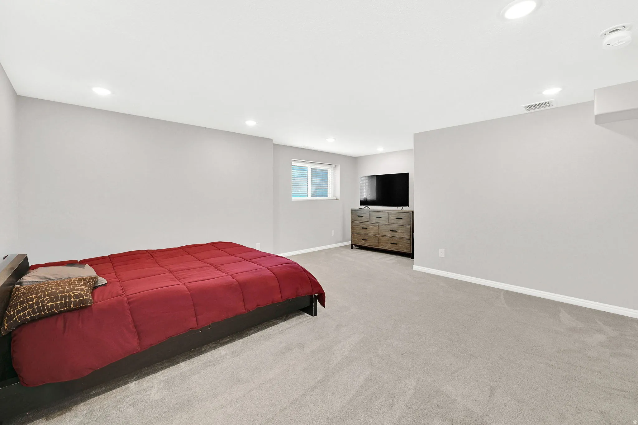 Recessed lighting, light gray walls, window, gray carpet, and white trim