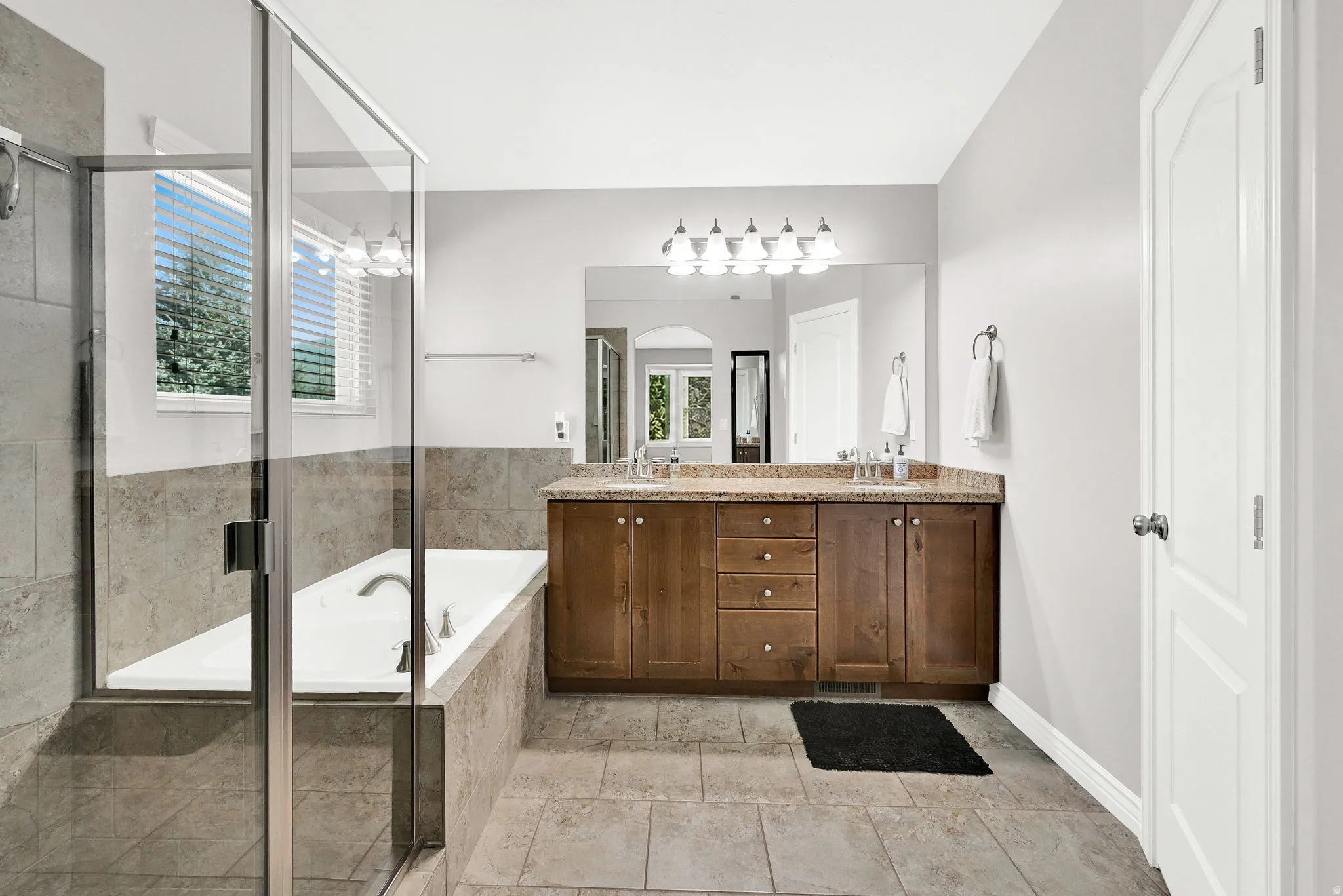 Dual sink vanity with wood-finish cabinetry and granite countertop