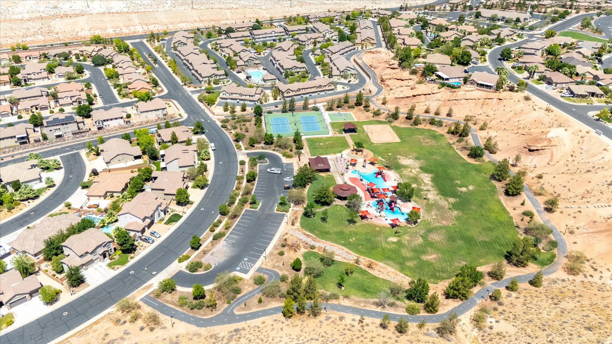 Community green space with established landscaping, playground equipment, tennis courts, and walking paths