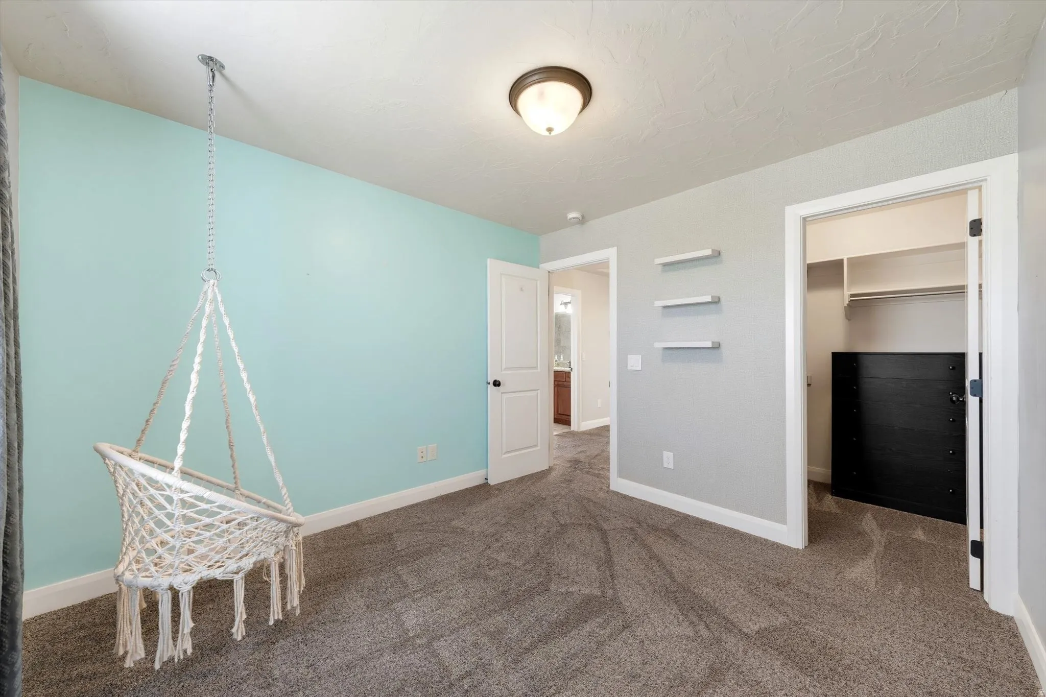 Plush carpet flooring, recessed ceiling lighting, built-in shelving, and a dedicated closet space