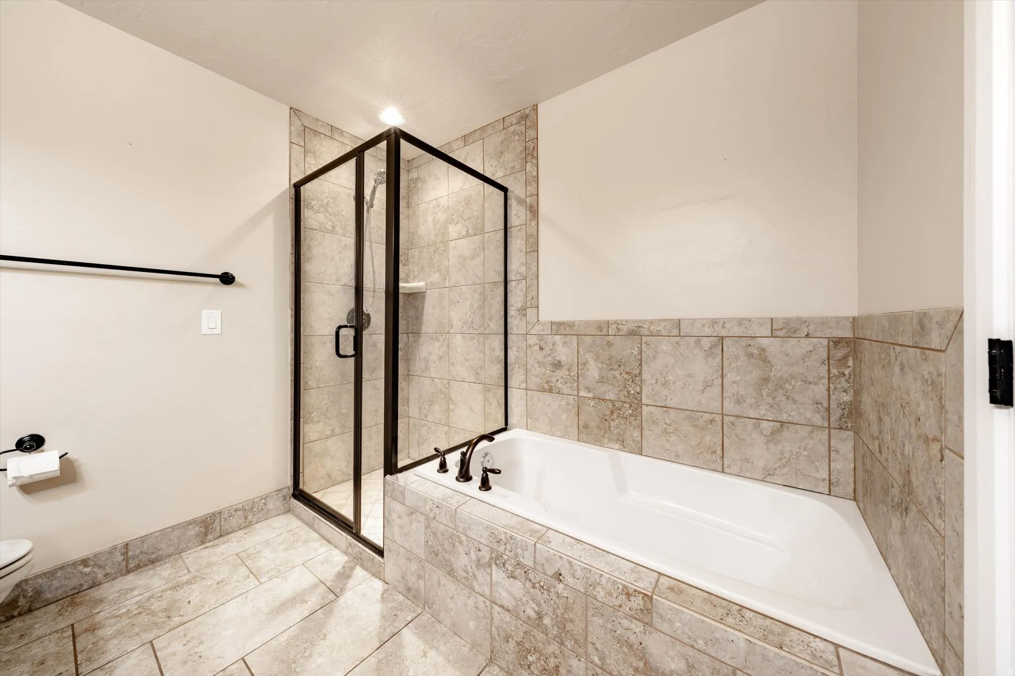 Corner glass-enclosed shower with dark bronze framing