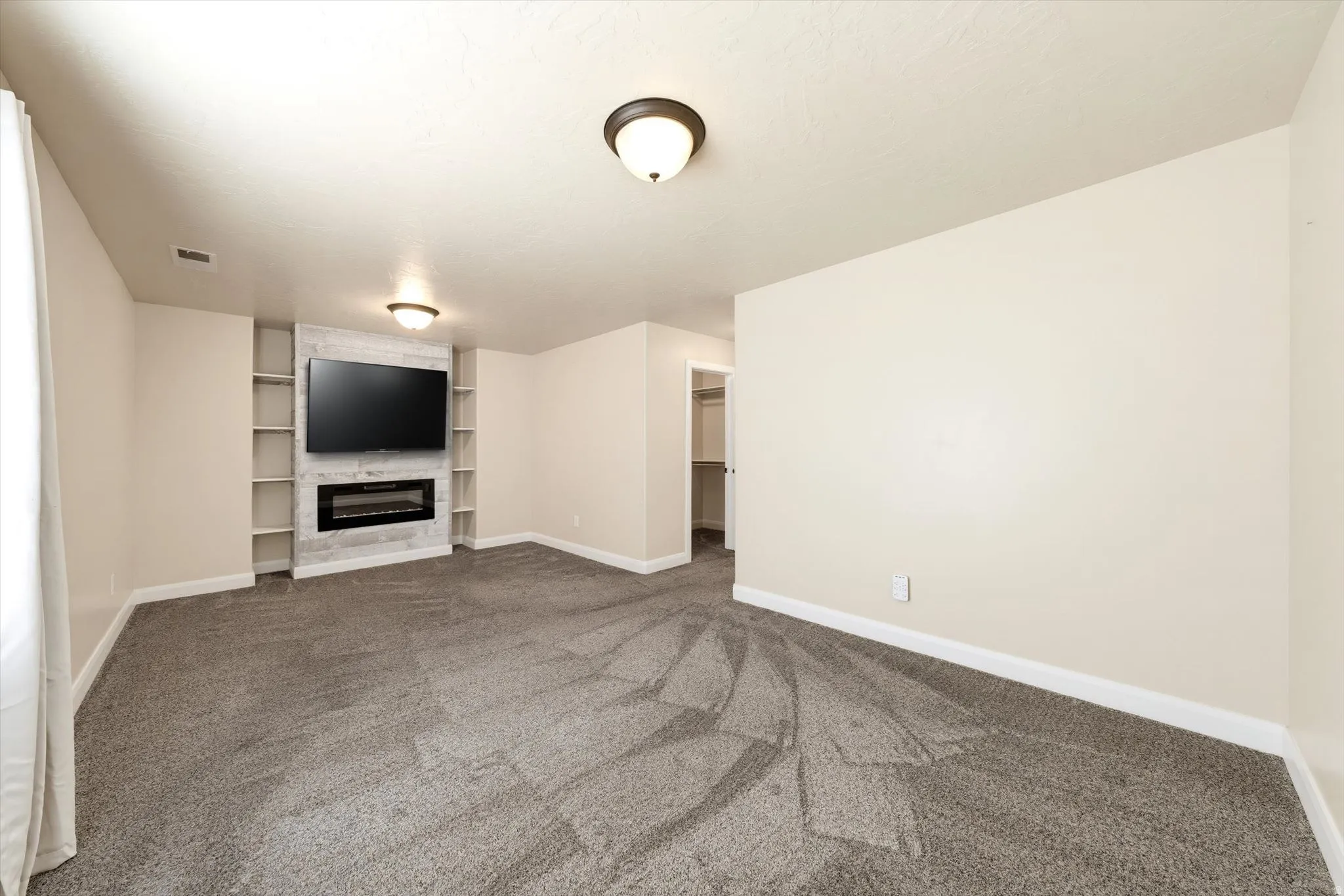 Built-in entertainment center featuring an electric fireplace and integrated shelving