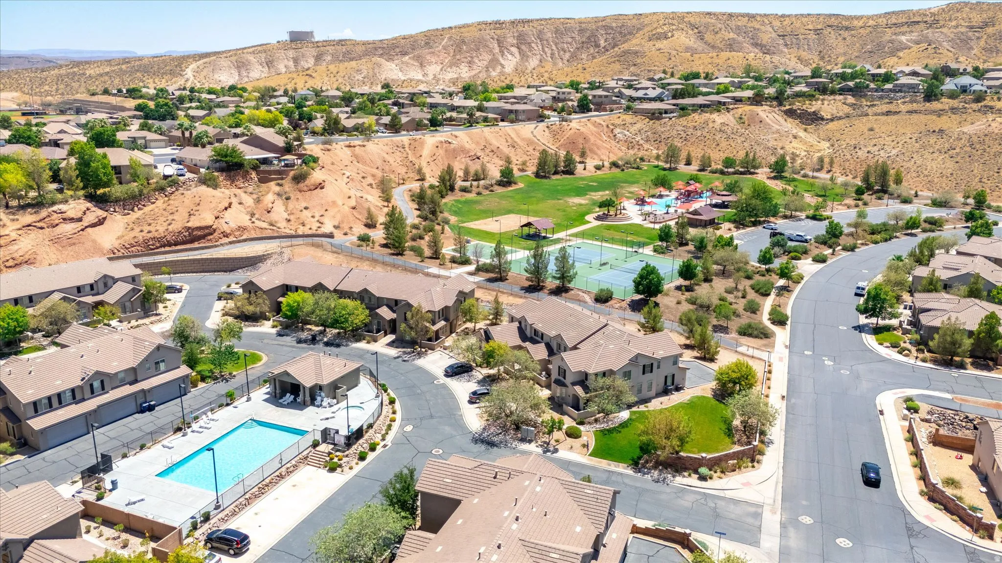 Community swimming pool with surrounding fence and lounge seating