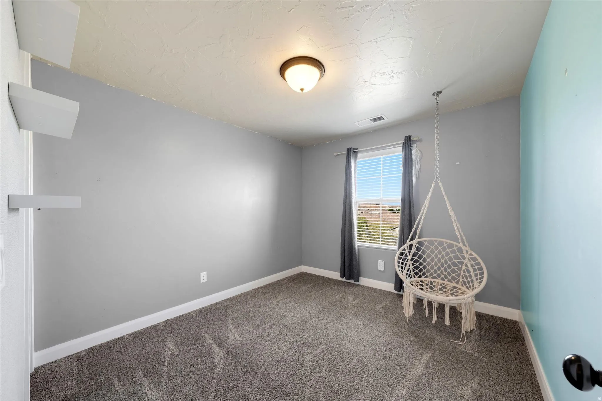 Wall-to-wall carpeting and a single window with blinds