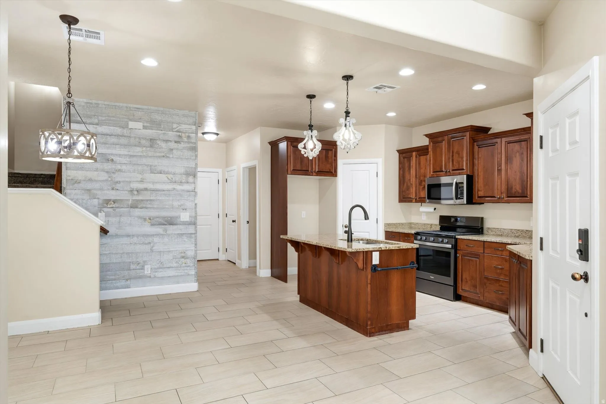 Well-appointed kitchen featuring wood cabinetry, granite countertops, and stainless steel appliances