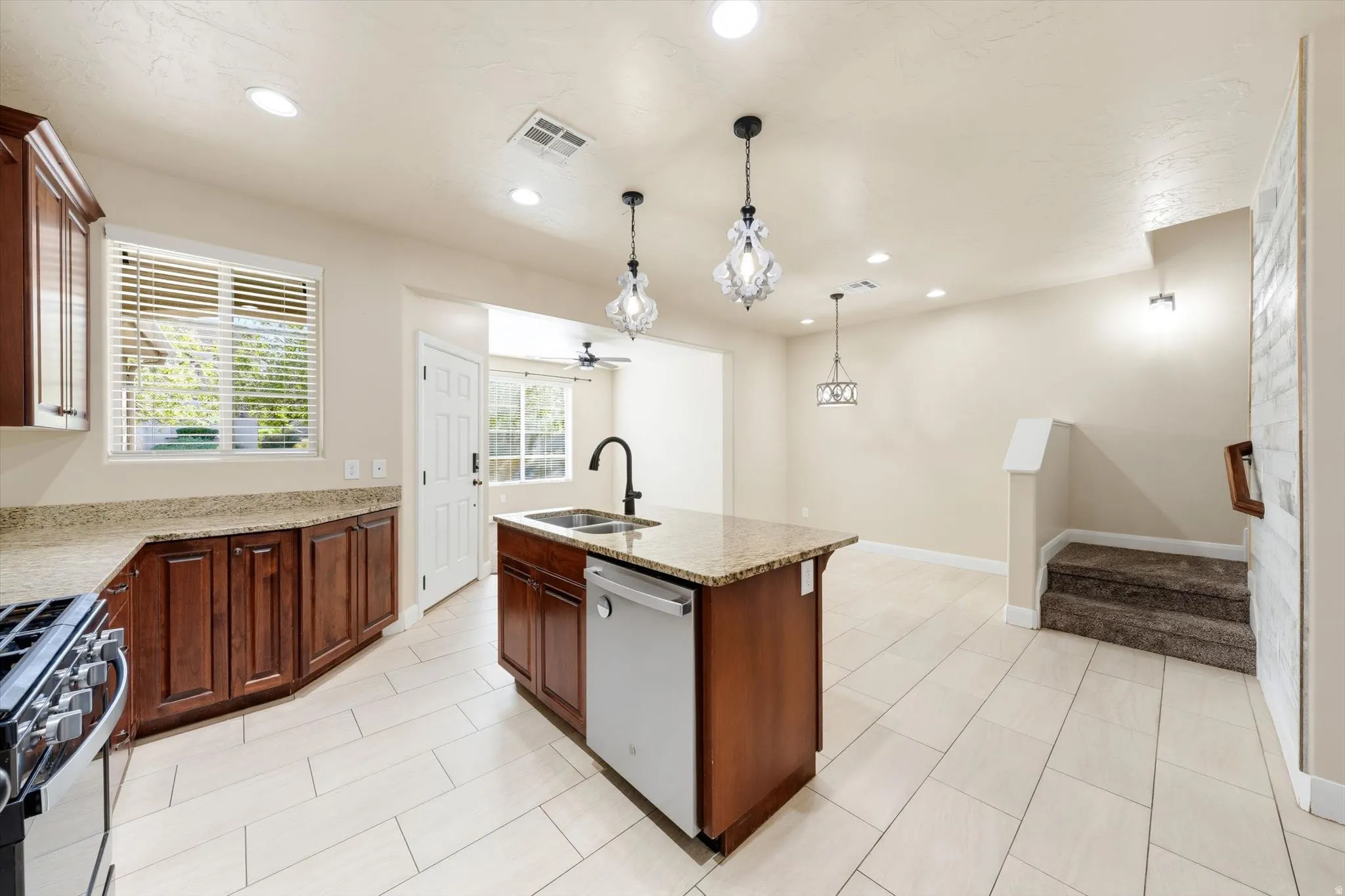 Kitchen featuring wood cabinetry, light-toned countertops, and a center island with a built-in sink