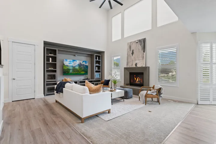 Vaulted ceilings, wood-finish flooring, custom built-in entertainment center, contemporary fireplace, and plantation shutters