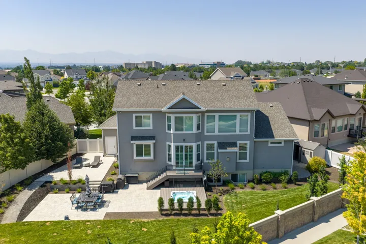 Rear exterior with multi-level deck, integrated hot tub, and expansive patio
